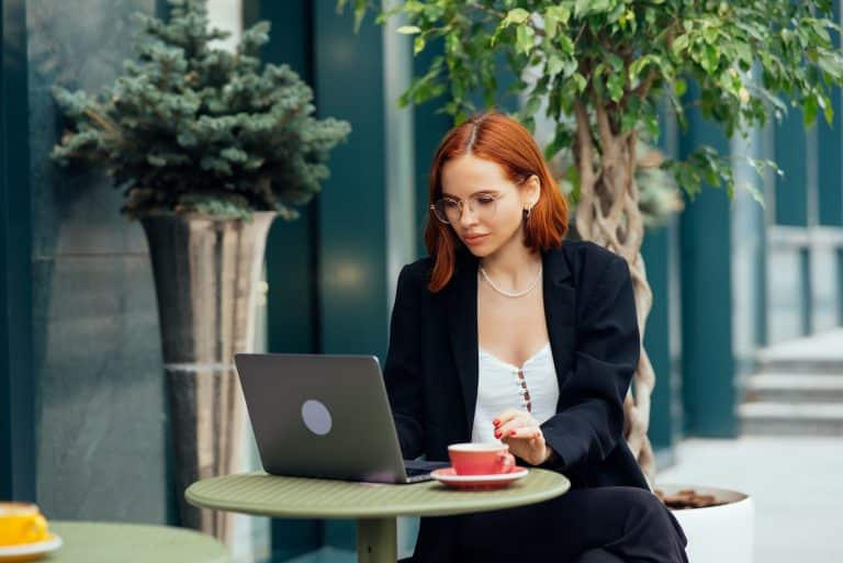 Beautiful woman working on laptop at outdoors cafe