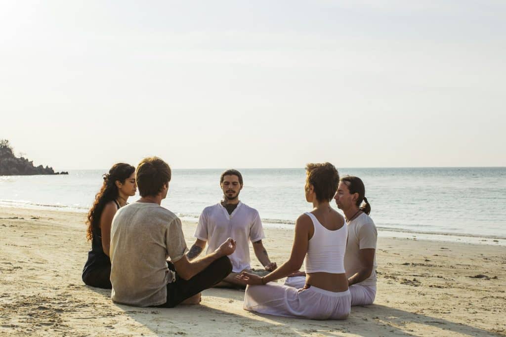 Thailand, Koh Phangan, group of people meditating together on a beach