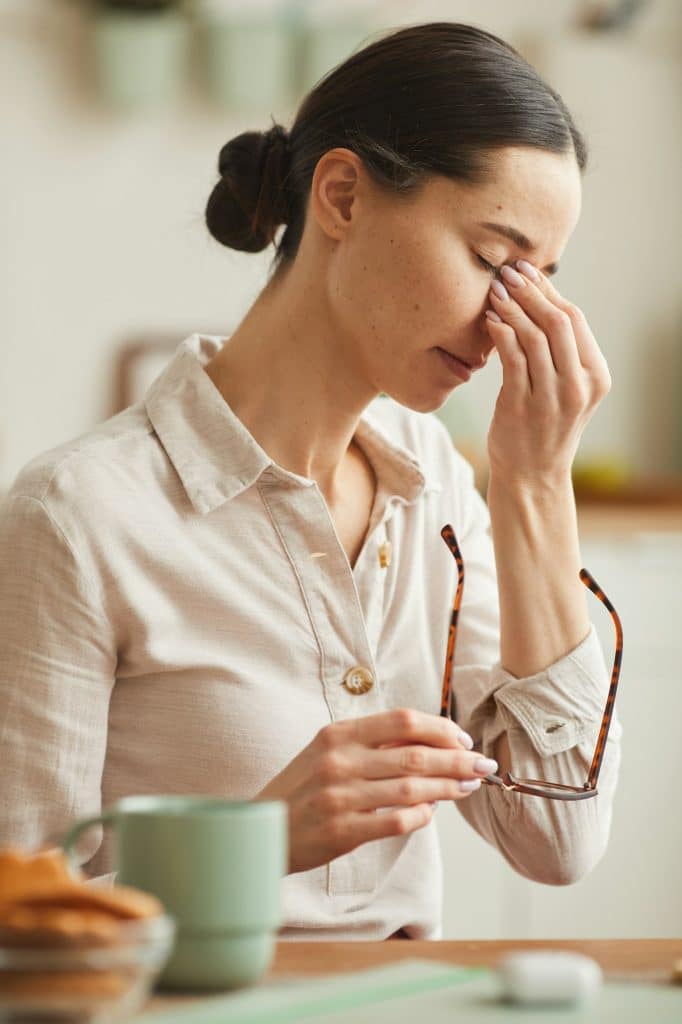 Stressed Young Woman Taking off Glasses