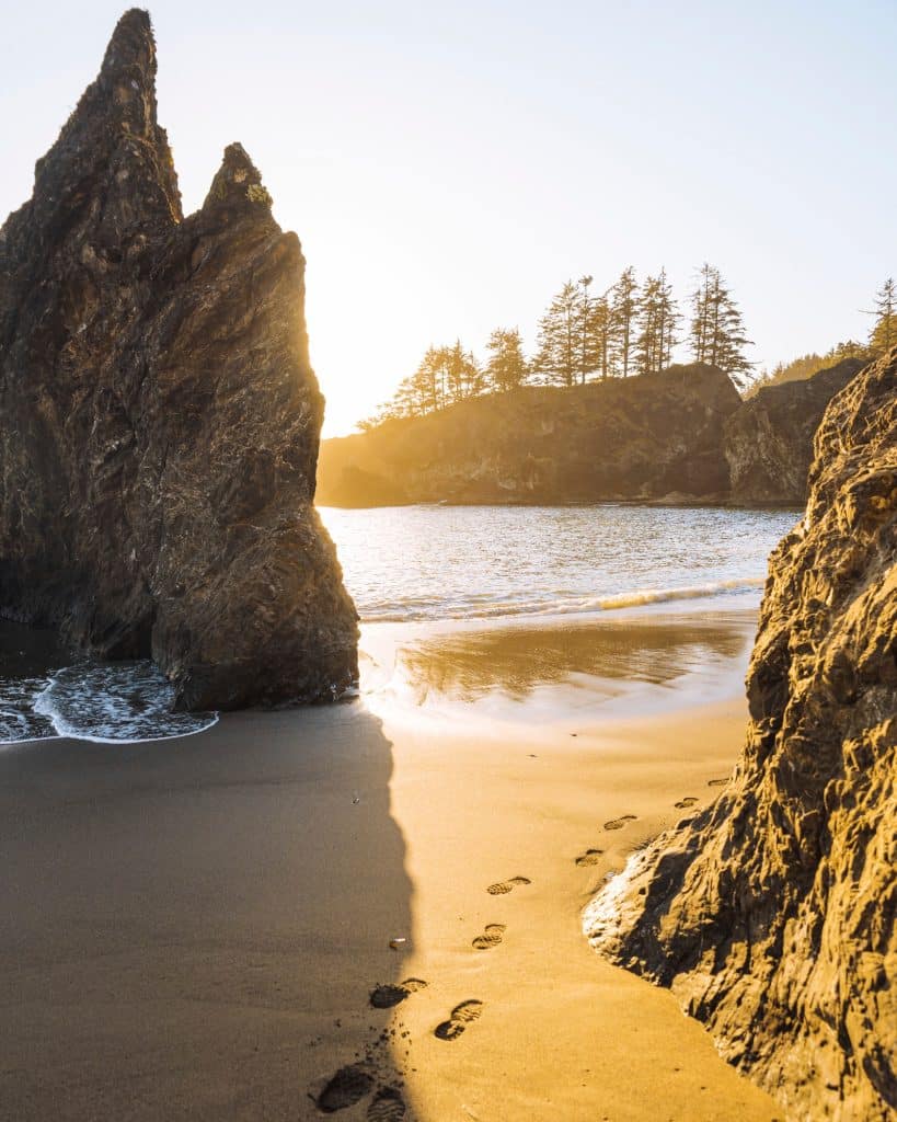 Golden hour at a serene beach with footsteps in the sand